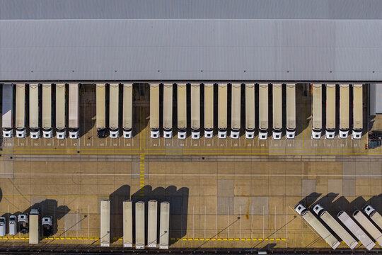 Aerial view of Hemel Hempstead Industrial Estate with rows of semi-trailers parked at a large warehouse loading dock in London, England, United Kingdom.