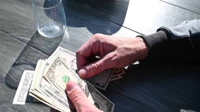 A man is counting US banknotes.
