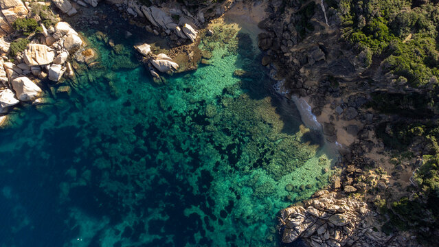 Aerial view of the turquoise waters and granite rock formations of Capo Testa in Santa Teresa Gallura, Sardinia, Italy.