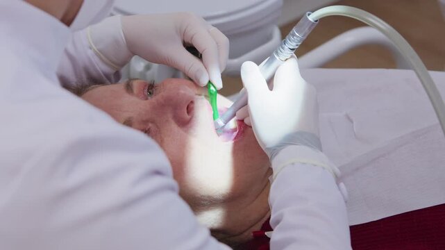 Close-up of dentist hands treating a teeth cavity of a mature woman in clinic
Professional dentist hands treating tooth decay of a female patient with dental tools
