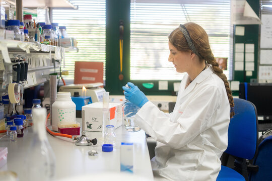White woman scientist conducting research with glass beaker