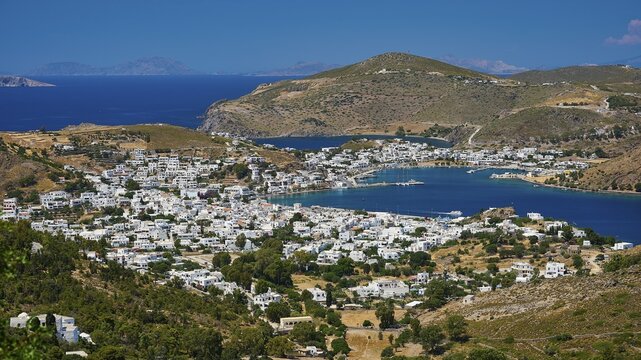 Picturesque coastal town with white houses and mountains in the background, surrounded by blue sea in Mediterranean climate, Skala, Patmos, Dodecanese, Greek Islands, Greece