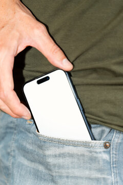 White person putting smartphone into front pocket of blue jeans
