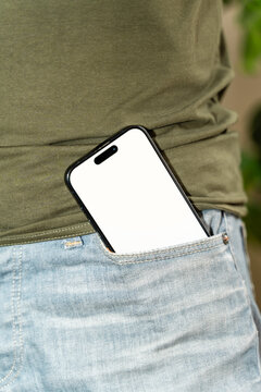 Smartphone in jeans pocket with white person wearing green shirt