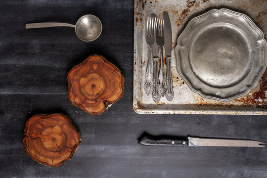 Old various kitchen utensils on black chalkboard background. Food themed flat lay.