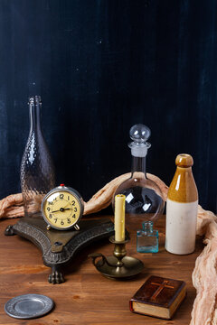 Various old vintage objects on brown wooden table by the black wall. Still life.