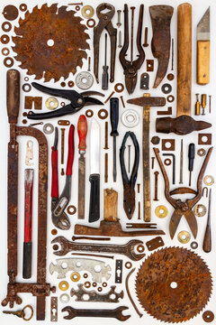 Flat lay of old hand tools on white background. Large collection of various rusty tools and bits arranged on white.