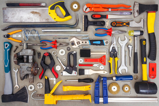 Flat lay of old and new hand tools on concrete background. Large collection of various tools and bits arranged on concrete.