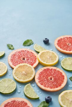 Fresh citrus slices with water drops on blue background