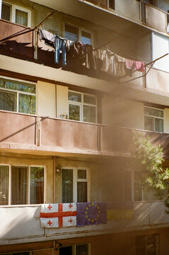 Apartment building in Tbilisi, Georgia, with flags displayed.