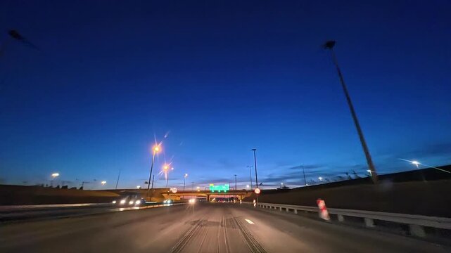 Timelapse of highway At Dusk Under Streetlights With Deep Blue Evening Sky