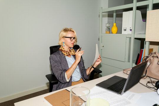 Woman Walks in Office Space While Holding a Drink