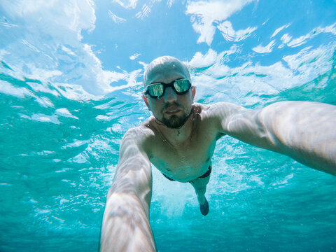 Man Taking Underwater Swimming Selfie
