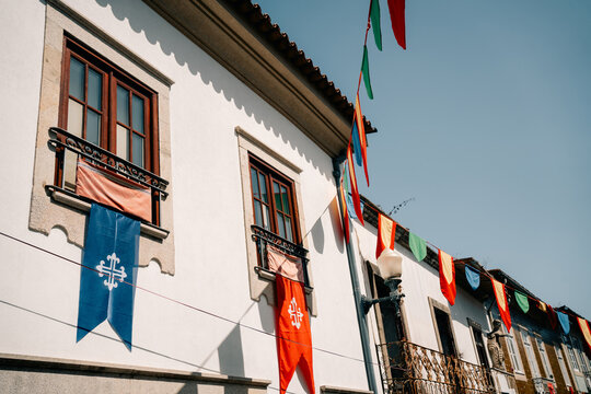 Festive Decorations and Flags Hang From Buildings in a Town Square