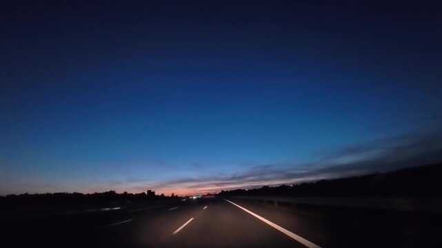 Timelapse of highway At Dusk Under Streetlights With Deep Blue Evening Sky