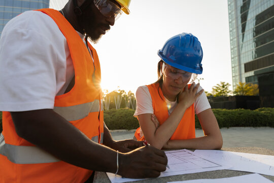 Construction workers discussing building plans outdoors