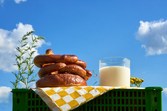 Fresh Pretzels and Milk on a Picnic Cloth Under a Bright Summer Sky