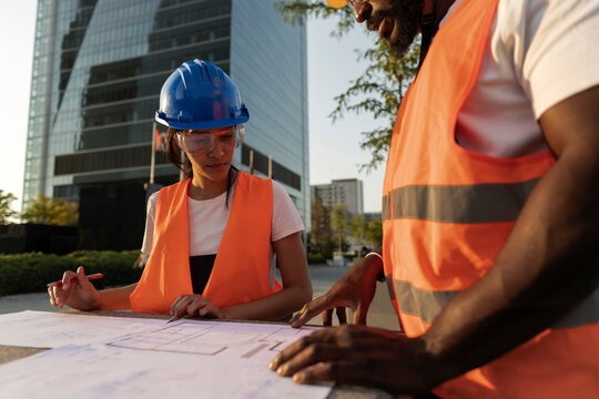 Construction workers reviewing architectural blueprints