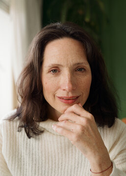 Woman Sitting Indoors With a Thoughtful Expression