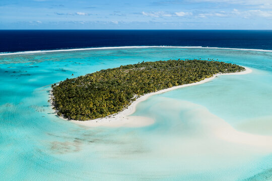 Aerial view of Aitutaki island surrounded by a turquoise lagoon and white sandy beaches in the Cook Islands.