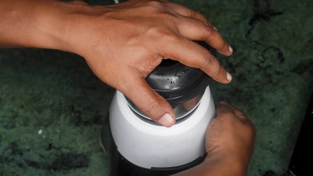 A person to pouring of tomato in blender and paste of spices in kitchen for cooking preparation. Food mixer grinder, Food Processor and Grinder. Culinary Kitchen Appliance.