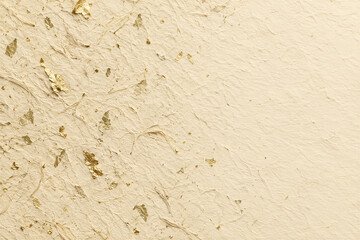 Fototapeta premium Textured handmade paper background with gold leaf flakes, cream colored fibrous surface, elegant organic pattern. Luxury stationery, wedding invitation template, fine art backdrop.