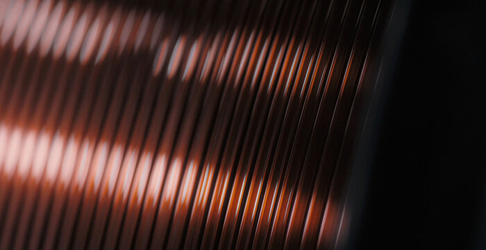 View of tightly wound copper wire on a spool, showcasing the metallic texture and reflective surface in an industrial setting, Buffalo, New York, United States.