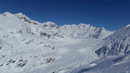 Obraz premium Snow-covered glacier basin and mountain peaks in the Swiss Alps