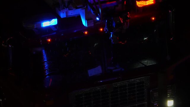Fire emergency truck on accident scene at night. First responders fire vehicle rescue at city street. Fire truck with flashing emergency lights at night.