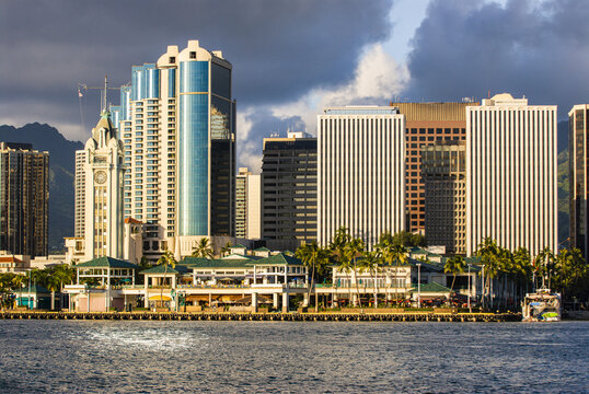 View of the Honolulu skyline featuring the historic Aloha Tower, modern skyscrapers, and palm trees along the waterfront Honolulu, Hawaii, United States.