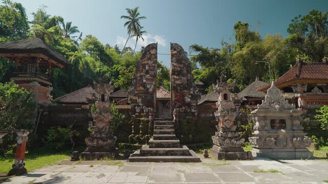 Traditional stone entrance and sacred water pools at Pura Gunung Kawi Sebatu Hindu temple in Ubud, Bali, Indonesia