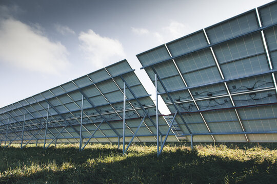 View of solar panels with metal support structures and wiring in a grassy field in Tartu County, Estonia.