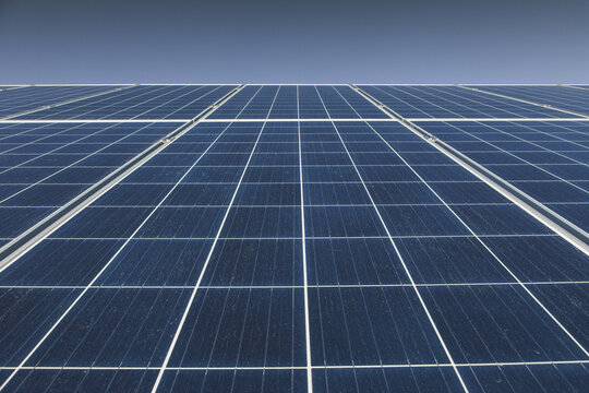 View of solar panels arranged in a grid pattern against a clear blue sky in Tartu County, Estonia.