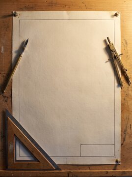 Blank Drafting Paper With Border On Wooden Board With Brass Compass