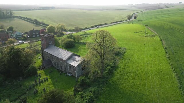 Ancient stone church stands amid rolling green fields