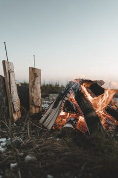 View of Vormsi island where fish are being smoked on wooden planks over an open campfire on the rocky beach in Laane County, Estonia.