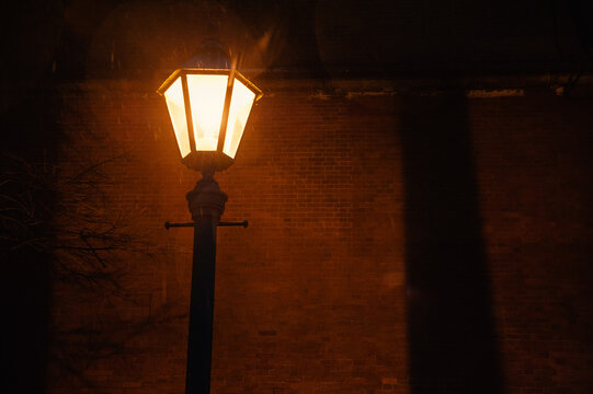 Vintage lantern casts warm glow against brick masonry