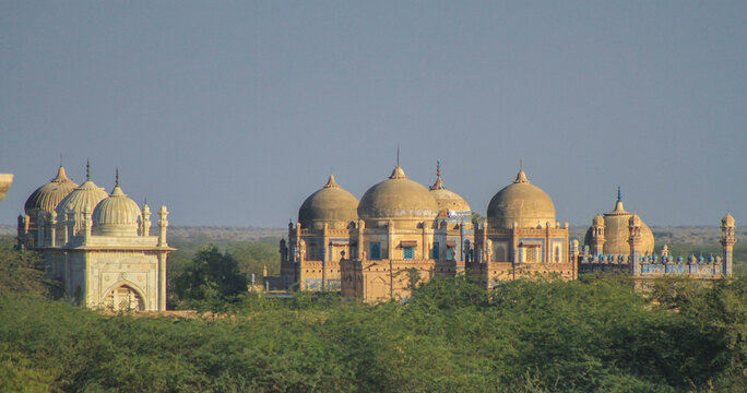 View of the historic Abbasi family tombs with their distinctive domes and intricate blue tile work set against the arid landscape of the Cholistan Desert in Bahawalpur, Punjab, Pakistan.