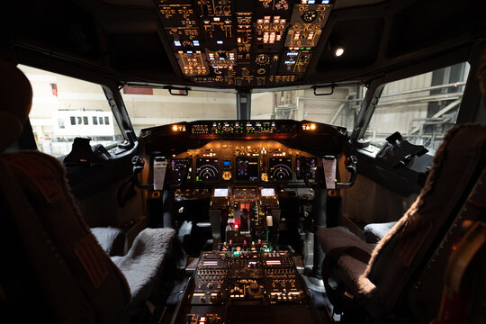 View of the illuminated cockpit of a Boeing 737-800 aircraft with detailed flight instruments and controls at Langenhagen, Niedersachsen, Germany.