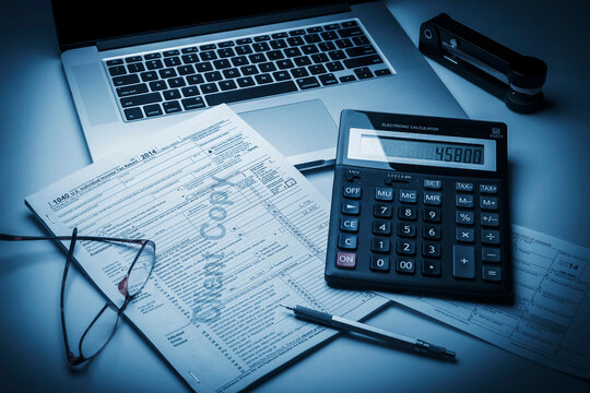 Financial accounting with laptop and calculator. Business analysis of tax documents.