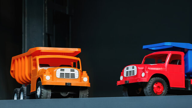 Two colorful plastic toy dump trucks.