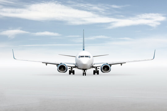 Front view of the passenger airliner isolated on bright background with sky