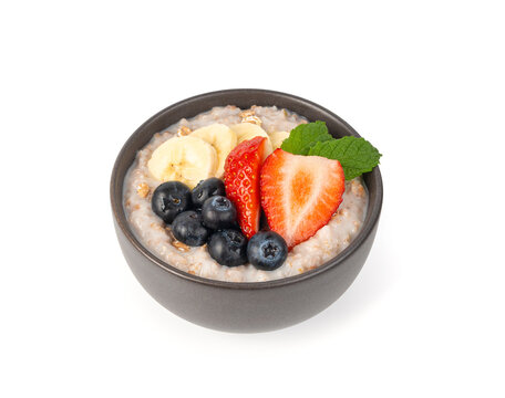 Cooked spelt in bowl isolated. Oatmeal milk porridge with fruits and berries