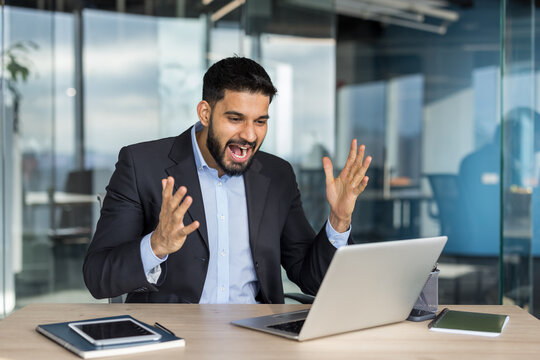 Excited businessman celebrating success and achievement in office