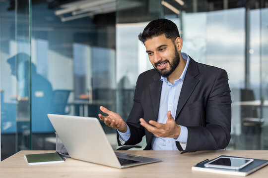 Young businessman having video call on laptop in office