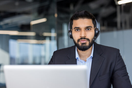 Young man in headset working at laptop
