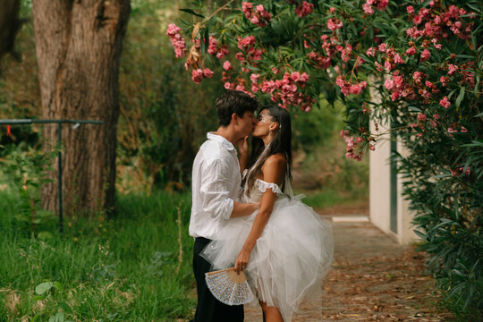 Wedding Couple Kissing On A Leafy Path