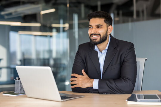 Smiling indian businessman working at office desk