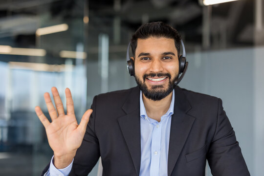 Smiling businessman wearing headset greeting on video call