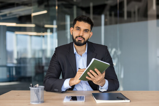 Professional businessman writing notes during a business meeting
